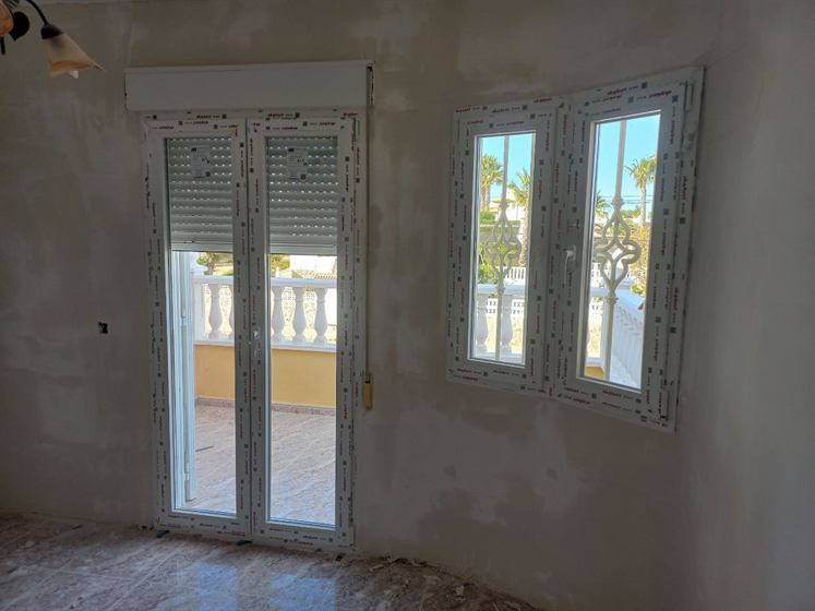 Zweiflügelige Kunststoff-Balkontür und Fenster mit Rollläden