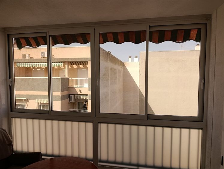 Mit Aluminium-Schiebefenstern verglaster Balkon, von innen