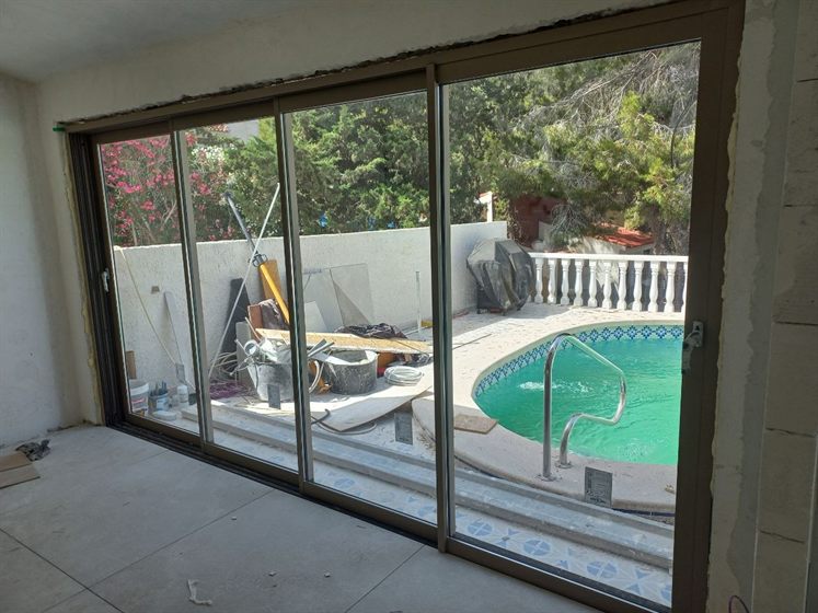 Corredera de aluminio de 4 hojas frente a la piscina