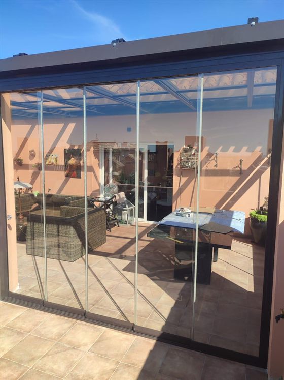 Dachterrasse mit Glasvorhang und Pergola
