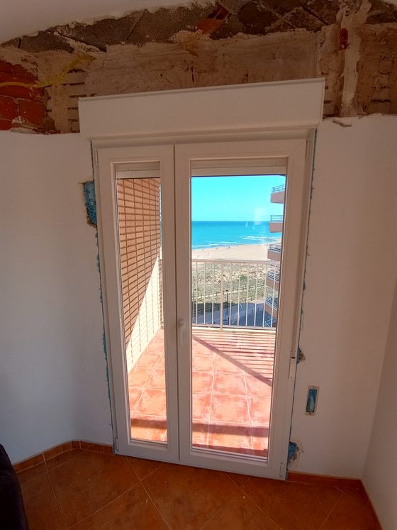 Puerta de PVC a la terraza frente a la playa