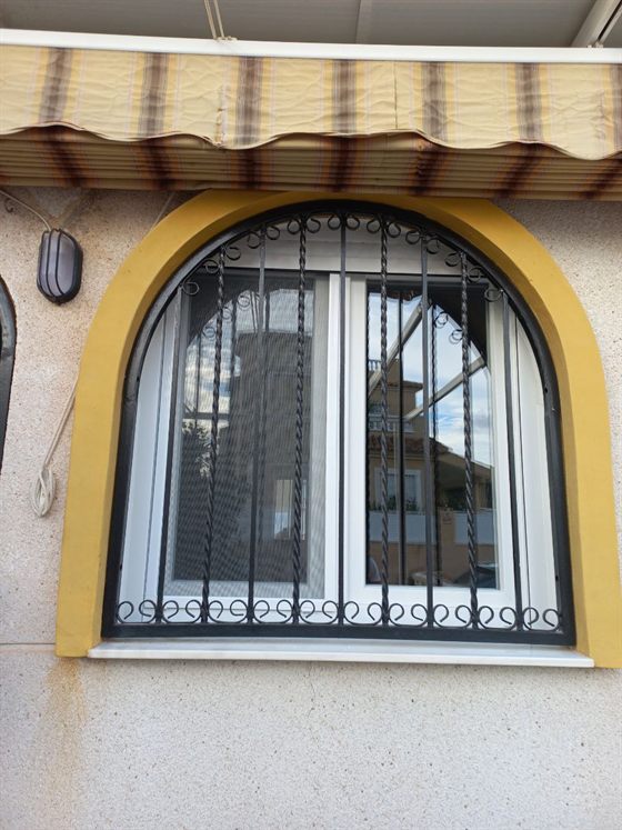 Kunststofffenster in einer Bogenöffnung, mit Gitter